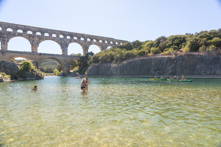 Remoulins , France - august 12, 2016:people swim and canoe near the Pont du Gard Roman aqueduct during a sunny dayのeditorial素材
