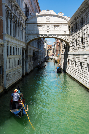Venice,Italy -August 17,2014:A gondola passes under the bridge of sighs in Venice during a sunny dayのeditorial素材