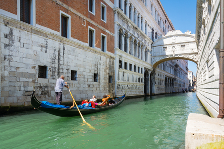 Venice,Italy -August 17,2014:A gondola passes under the bridge of sighs in Venice during a sunny dayのeditorial素材