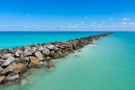 People on the rocks of Miami beach during a sunny dayのeditorial素材