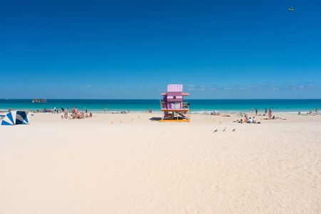 Miami,USA-march 15,2018:people near of one of the famous and colorful beach guard cabins on Miami beach during a sunny dayのeditorial素材