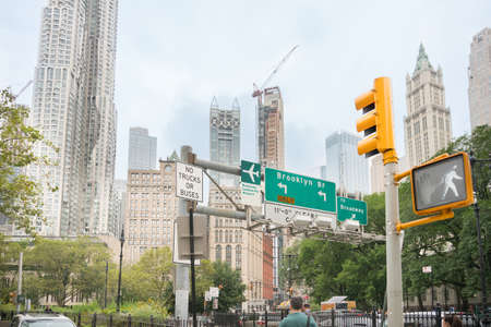 New York City, USA - August 6, 2019:Daily life in New York city during a cloudy day.Here a view of a sckyscrapers, road signs and a pedestrian traffic lightのeditorial素材
