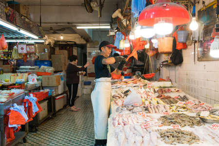 Hong Kong,March 24,2019:People among the classic markets in the narrow and crowded streets of Hong Kong during a cloudy dayのeditorial素材