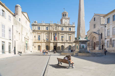 Arles,France-august 14,2016:people stroll in the square where the city hall and the obelisk of Arles are located during a sunny dayのeditorial素材