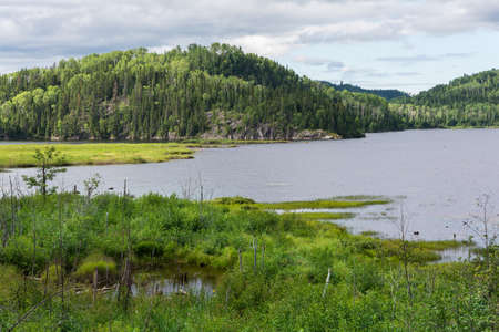 Walking through the lakes and mountains of wild Canada during a cloudy dayのeditorial素材
