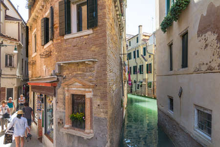 Venice, Italy-August 17,2014: This is a typical view of Venice with its canals and narrow streets full of tourists during a sunny day.のeditorial素材