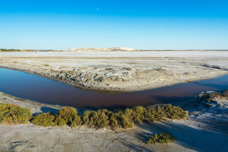 View of a canal that crosses a salt pan in the Camargue during a sunny dayの写真素材