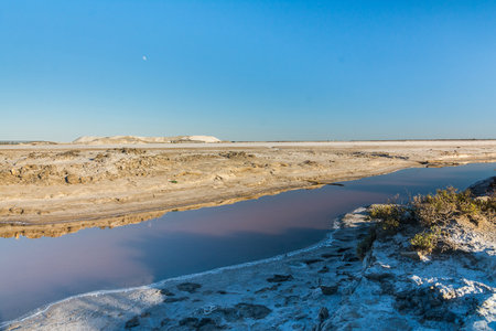View of a canal that crosses a salt pan in the Camargue during a sunny dayの写真素材