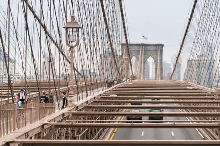 New York City, USA - August 6, 2019: People walk across the famous Brooklyn Bridge during a cloudy day.のeditorial素材