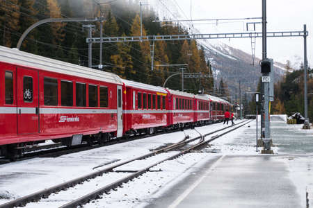 Cavaglia, Switzerland-november 2, 2018: Snow-covered trainstation of Cavaglia along the way of the red train of the bernina during a cloudy day.のeditorial素材