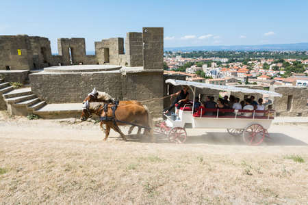Carcassonne, France-august 15,2016: people visit the fortified city of Carcassonne on a horse-drawn carriage during a sunny dayのeditorial素材