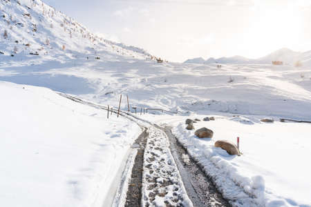 Snow-covered landscape in the autumn along the way near Livigno in a sunny dayの写真素材