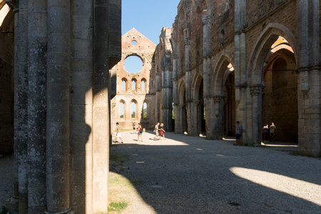 San Galgano ,Italy-august 8,2020:Tourists visit the interior of the abbey and former monastery of San Galgano famous for being roofless during a sunny day in Tuscanyのeditorial素材