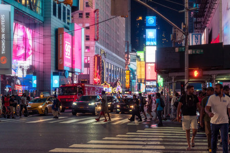 New York City, USA - August 9, 2019:People and tourists stroll among the lights and skyscrapers of Time Square in Manhattan during a summer nightのeditorial素材
