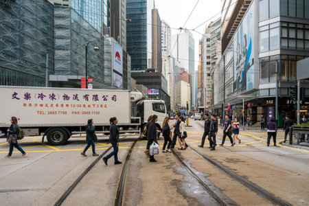 Hong Kong,March 25,2019:people among the skyscrapers through the streets of Hong Kong during a cloudy dayのeditorial素材