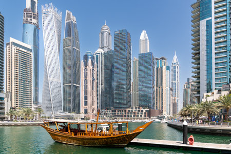 Dubai, United Arab Emirates - March 12, 2023:View of Dubai skyscrapers and traditional boats while...