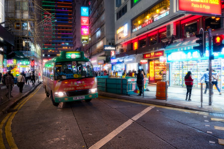 Hong Kong,March 25,2019:people and traffic among the skyscrapers through the streets of Hong Kong during a nightのeditorial素材