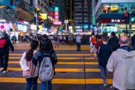 Hong Kong,March 25,2019:people among the skyscrapers through the streets of Hong Kong during a nightのeditorial素材