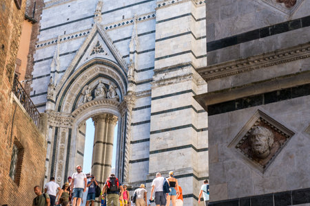 Siena ,Italy-august 10, 2020:Tourists between the Cathedral and the Baptistery of San Giovanni battista during a summer day in Sienaのeditorial素材