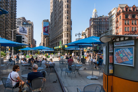 New York City, USA - August 9, 2019:people strolling among the famous skyscraper called Fatiron...