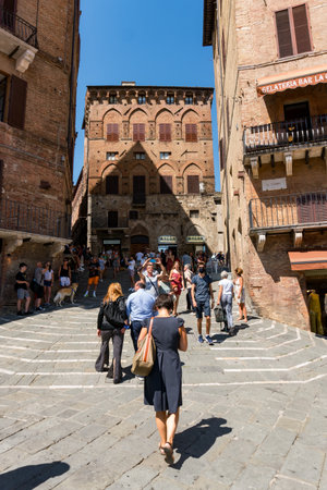Siena,Italy-August 10, 2020:People and tourists visit the famous Piazza del Campo during a sunny dayのeditorial素材