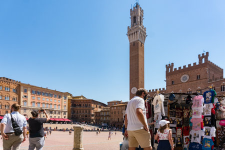 Siena ,Italy-august 10, 2020:Tourists and souvenir shops in Siena near the Campo square during a sunny dayのeditorial素材