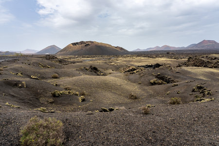 Los Cuervos Volcano, a caldera that can be visited in a barren area dotted with rocks during a sunny dayの写真素材
