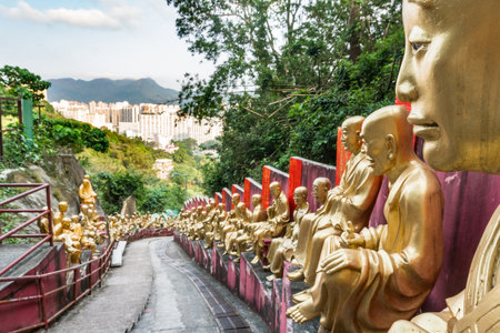Hong Kong,March 27, 2019:The long and steep staircase with Buddha statues leading to the famous Ten Thousand Buddhas Monastery during a cloudy dayのeditorial素材