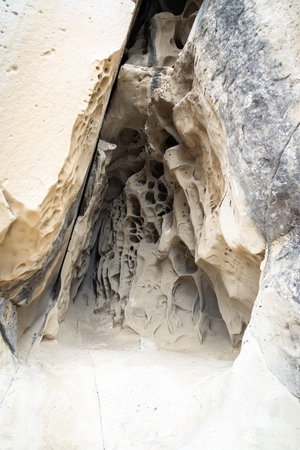 vertical photograph of the particular shapes created by the erosion of the Soprasasso caves on a cloudy dayの写真素材