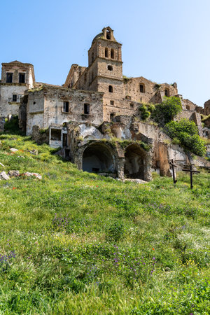 Craco, Italy-April 25, 2025:vertical photograph of ruins of the Mother Church of San Nicola in Craco in the middle of a meadow on a sunny dayのeditorial素材