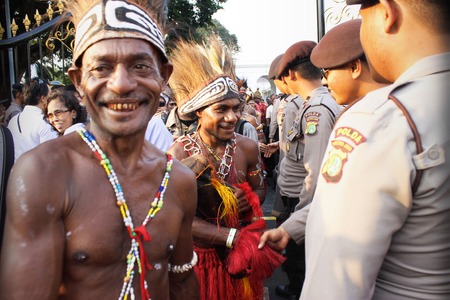 Jakarta, Indonesia - October 20, 2014 - Men in traditional cloth from Papua get handshake with police officers when exit from Indonesian presidential palaceのeditorial素材