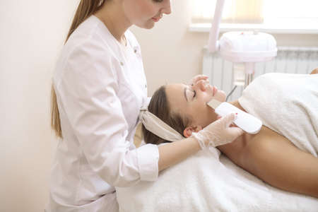 The beautician performs an ultrasonic cleaning procedure for the patient's skinの写真素材