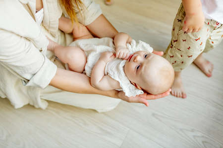 Young beautiful mom holds a newborn baby in her arms