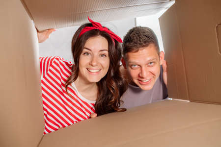 The girl and the guy watch the match on TV and cheer for the team, laugh, smile and eat popcornの写真素材