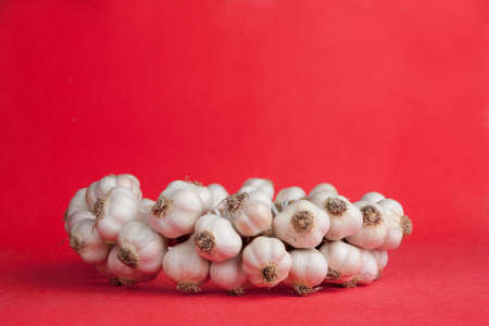 garlic bunch on a bright red の写真素材