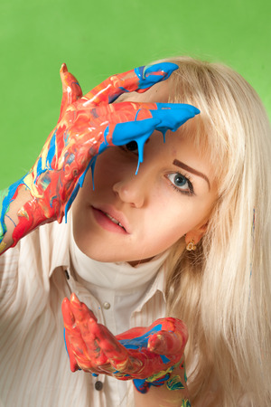 Portrait of an attractive woman with hands in fresh paintの写真素材