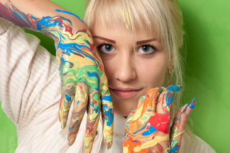 Portrait of a young girl with hands in fresh paintの写真素材