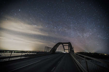 Starry Night Sky rising over a Bridgeの写真素材