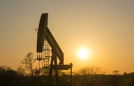The Sun sets behind a Texas oil well III.の写真素材