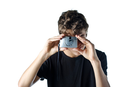 Teenage boy taking photo with compact camera - isolated on whiteの写真素材