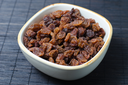 Bowl of raisins (dried grapes) on dark backgroundの写真素材