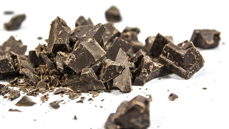 Pieces of dark chocolate bar isolated on white background in studio shotの写真素材