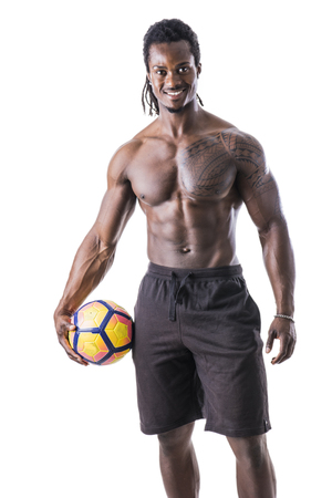 Muscular black man exercising with soccer ball in studio shot, isolated on whiteの写真素材