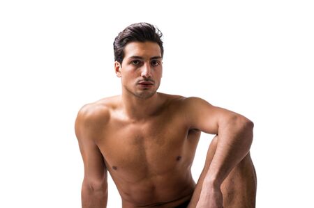 A handsome latin young man sitting naked on floor, wearing only underwear. Muscular buildの写真素材