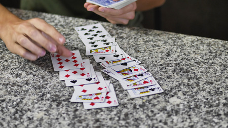 Two young men relaxing together and playing cards spending time at home.