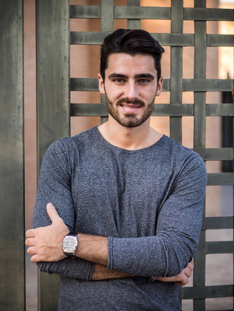 Attractive young bearded man portrait in urban setting, looking at cameraの写真素材