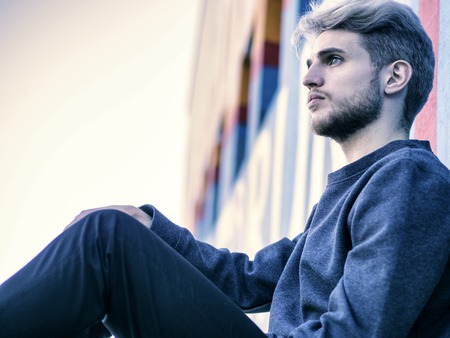 One handsome young man in urban setting in European city, standingの写真素材