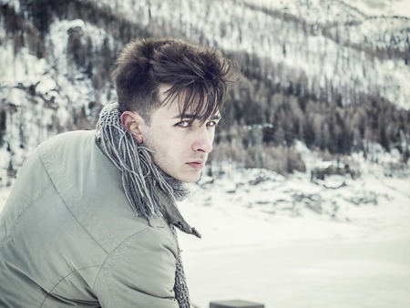 Young handsome man in winter sportswear looking awayの写真素材