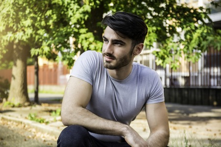 Handsome young man outdoor looking at camera, smiling