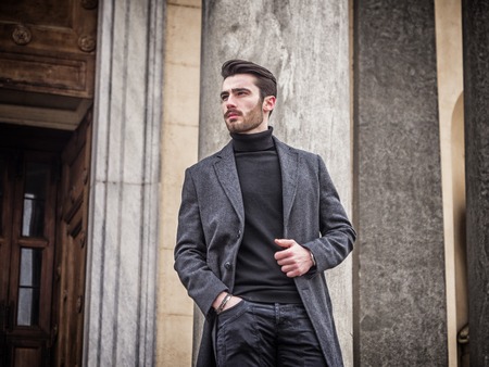 Handsome bearded young man outdoor in winter fashion, wearing black turtleneck sweater and woolen...